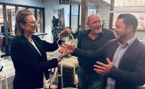 An engaged business meeting with professionals exchanging drinks at a modern office space.