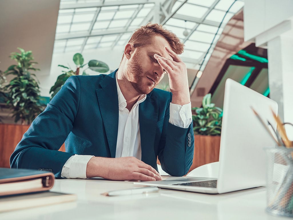 Local content procurement shown by a procurement worker overwhelmed by tender overload at a laptop